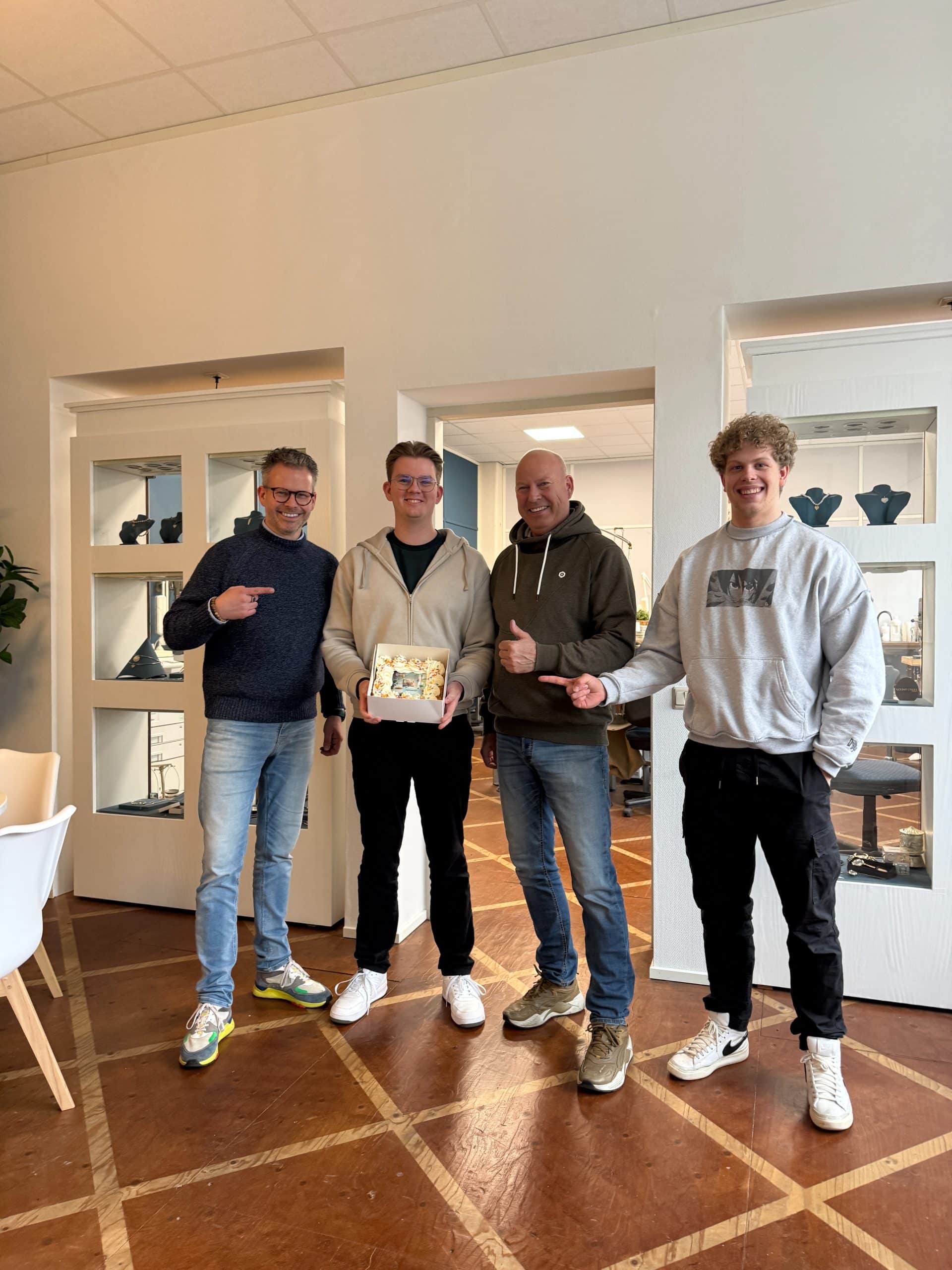 Ambachtelijke Websites groepsfoto met taart Golden Fingerprint Het team van Ambachtelijke Websites met een taart